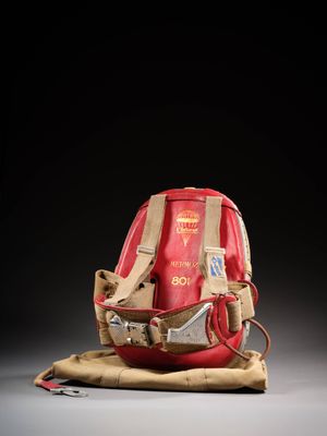 un gant de baseball posé sur un sac, sur une surface grise