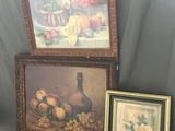 deux tableaux encadrés représentant des fruits et des fleurs posés sur une table, à côté d'un vase
