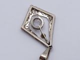 an image of a silver pendant with a clock on it ' s side