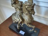 a statue of a man riding a horse on a wooden table