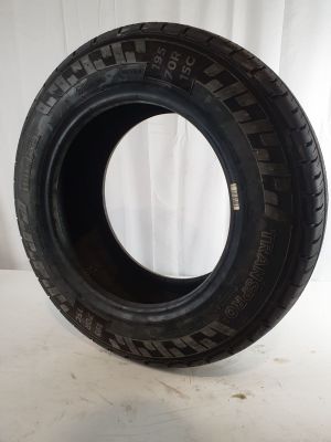 a close up of a tire on a white surface with a white curtain in the background