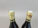 two bottles of wine sitting next to each other on top of a table