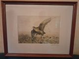 painting of a bird in flight in a frame on a table
