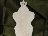 a white object on a green cloth with a cross on it