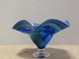 a blue glass vase sitting on top of a table