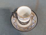 une tasse à café et sa soucoupe posées sur une table