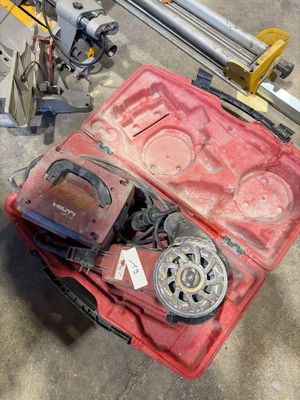une mallette rouge contenant des outils, posée par terre