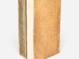 a close up of an old book on a white surface
