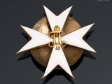 a close up of a gold and white cross on a black background