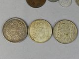 several coins are arranged in a row on a white surface