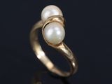 a close up of a gold ring with two pearls on it