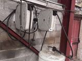 un chauffe-eau installé sur le mur d'un immeuble, à côté d'un réservoir d'eau
