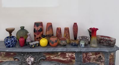 de nombreux vases de toutes sortes posés sur une table dans une pièce