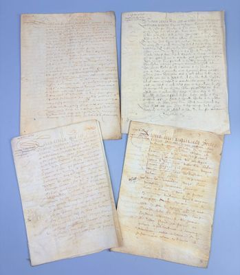 three old papers with handwriting on them sitting on a blue surface
