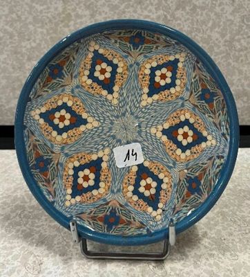 une image représentant une assiette bleue et orange ornée d'un motif floral