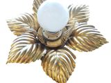 a gold leaf shaped candle holder with a light bulb on it