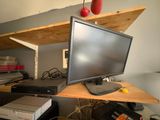 a computer monitor sitting on top of a wooden desk