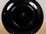 a black plate sitting on a table with a clear base