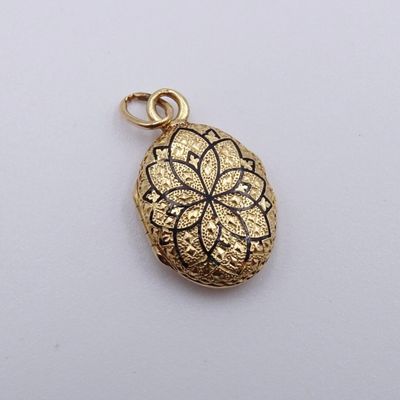 un pendentif plaqué or orné d'un motif floral