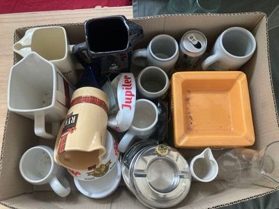 une boîte en carton remplie de tasses à café et de soucoupes