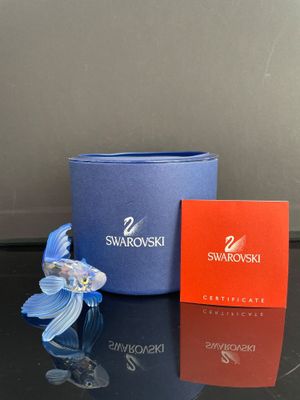 une fleur bleue et une boîte rouge posées sur une table noire
