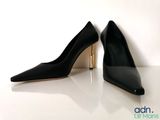 pair of black high heeled shoes on a white surface