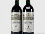 deux bouteilles de vin posées l'une à côté de l'autre sur une surface blanche