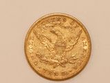 a close up of a gold coin on a white surface