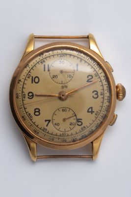 a gold watch on a white surface with a white background