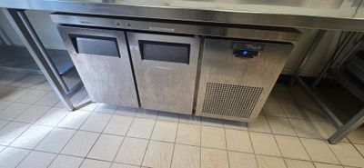 a stainless steel counter with two doors and a sink