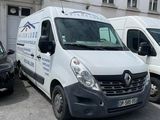trois fourgonnettes blanches garées sur un parking à côté d'un immeuble