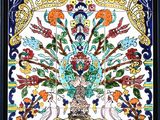 an ornately painted tile with flowers and birds in a vase