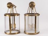 une paire de lanternes en laiton et en verre, chacune munie de bougies