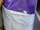 a purple and white bag sitting on top of a shelf