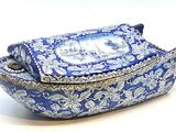une boîte bleue et blanche avec un couvercle, posée sur une surface blanche