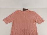 a pink sweater on a white surface