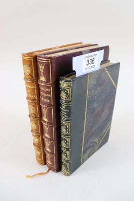 trois livres sont empilés sur une surface blanche