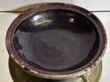 un bol marron posé sur une casserole en métal