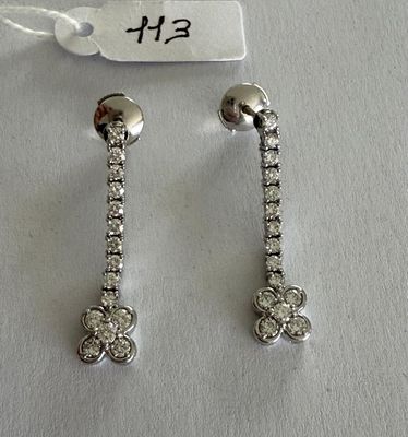 two pairs of diamond earrings on a white background with a price tag
