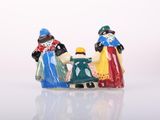 three figurines of three people sitting on a bench
