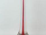 a glass vase with a candle inside of it on a white surface