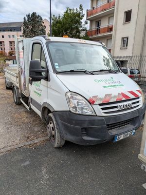 un camion blanc garé sur le bord de la route