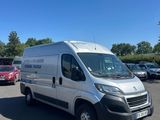 une camionnette blanche garée dans un parking à côté d'autres voitures