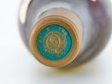 a close up of a bottle of wine on a white surface