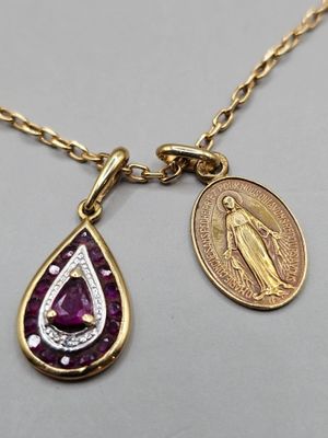 un gros plan d'un collier orné d'une pièce de monnaie et d'un pendentif sur lequel est fixée une pièce de monnaie