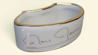 une photo d'un bracelet blanc et doré orné de deux cœurs