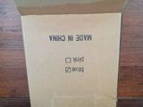 a cardboard box with a label on it sitting on a wooden floor
