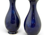deux vases bleus posés l'un à côté de l'autre sur une surface blanche