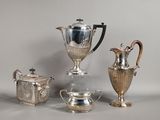 trois vases en argent et deux théières en argent posés sur une table