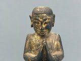 an image of a statue of a person sitting on a stool